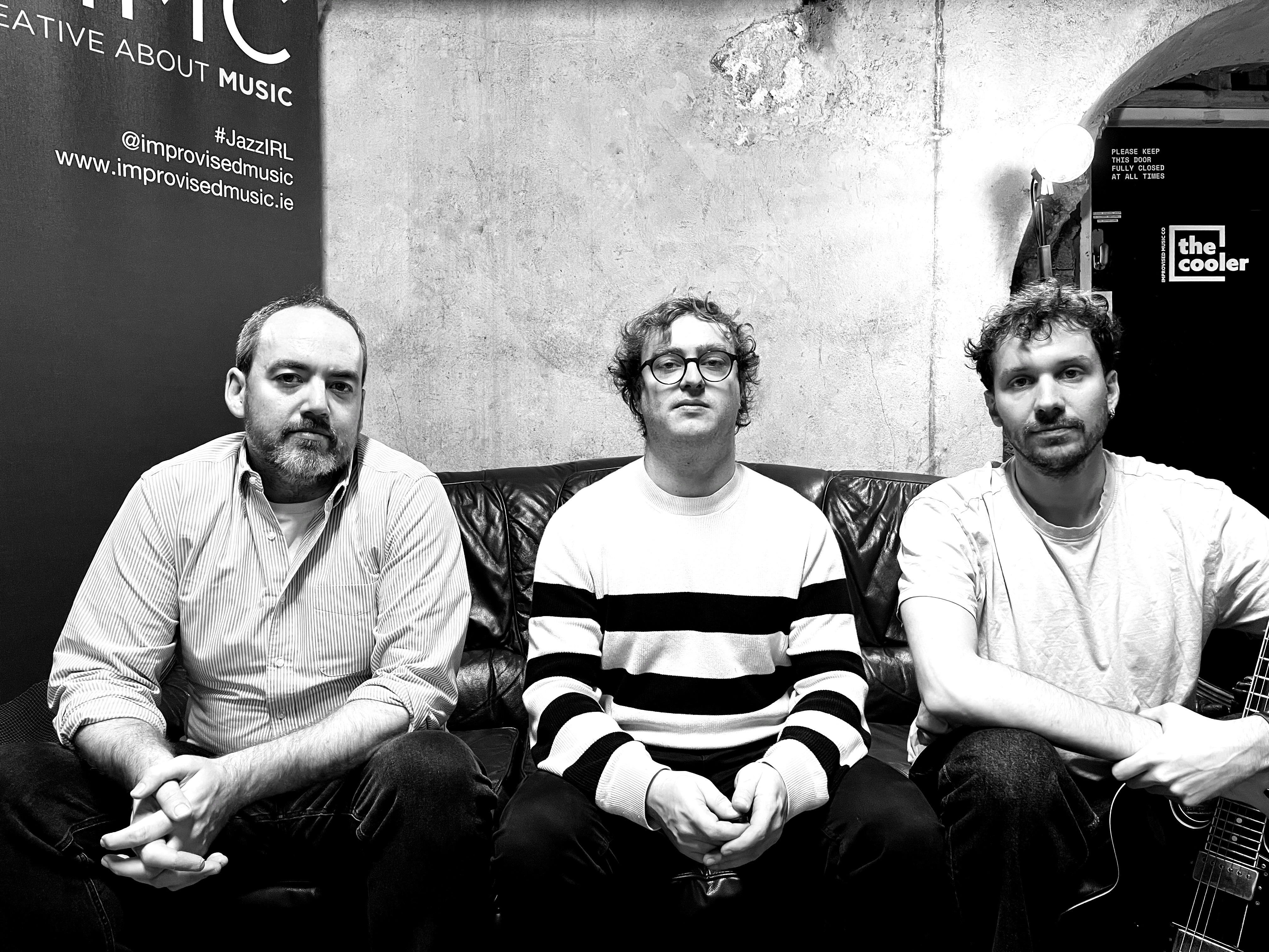 L.E.A. Trio — seated, black backdrop